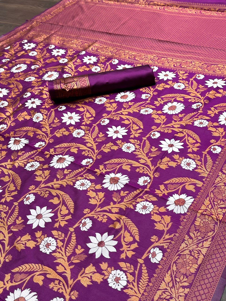 Close-up of the intricate floral print on a wine-colored Banarasi soft silk saree